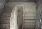 a curved edge concrete stairs with solid concrete balustrade